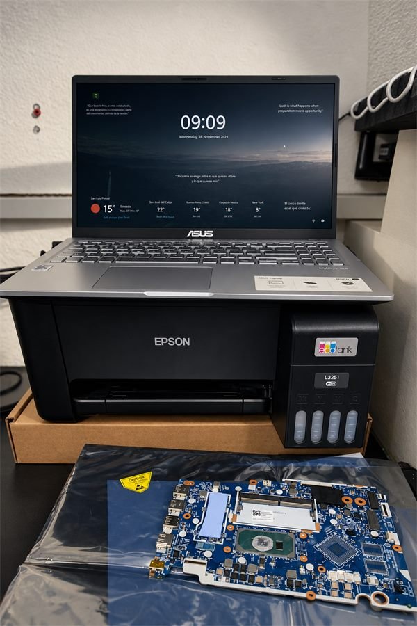 Laptop, impresora Epson y tarjeta madre listas para revisión en el taller de ASC